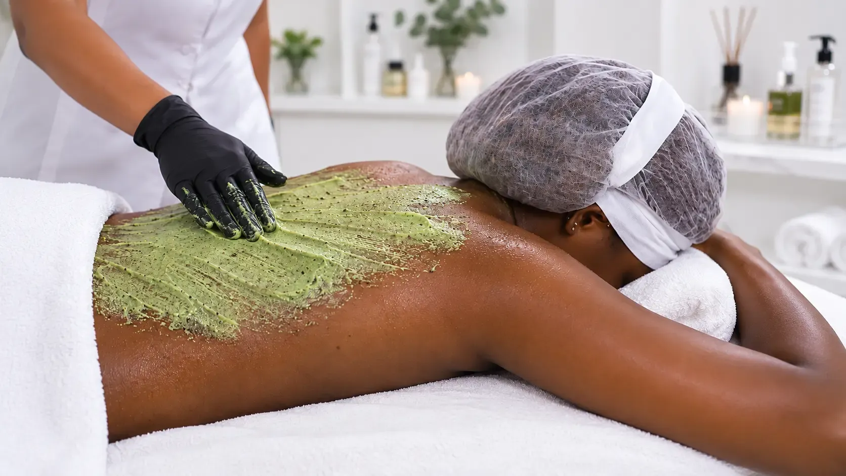 Gommage du dos réalisé dans une cabine de soins esthétiques